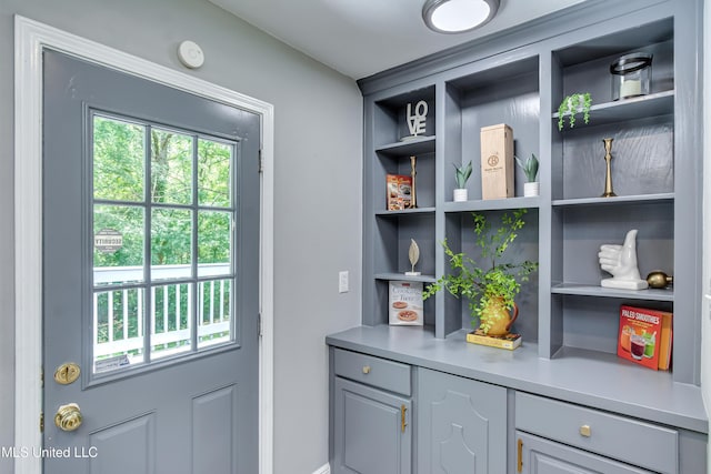 doorway to outside featuring built in shelves