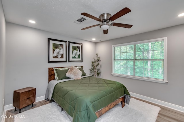 bedroom with baseboards, recessed lighting, wood finished floors, and a ceiling fan