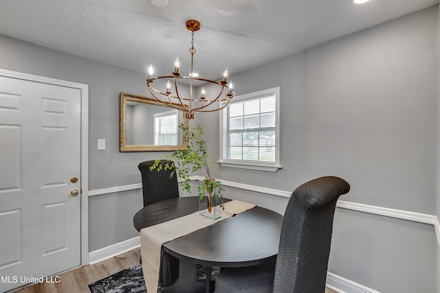 dining room with a chandelier, wood finished floors, and baseboards