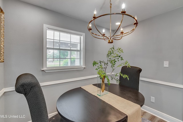 dining room with a chandelier and baseboards