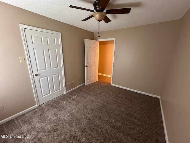 7807 S Chesterfield Dr, Southaven, MS 38671 - unfurnished bedroom with dark carpet, a textured ceiling, baseboards, and ceiling fan