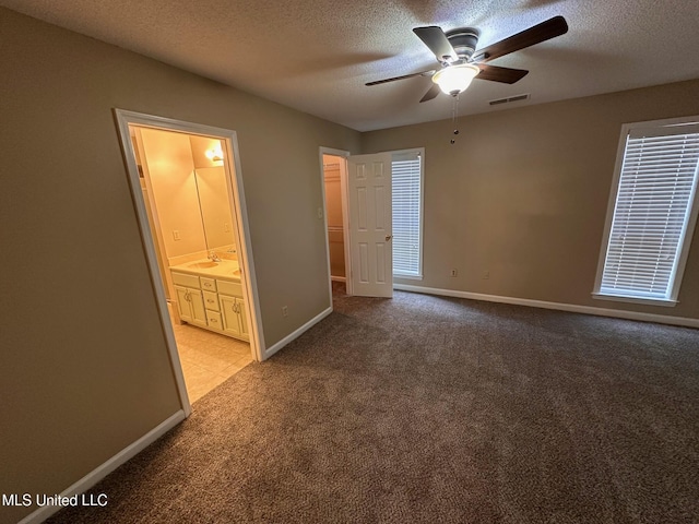 7807 S Chesterfield Dr, Southaven, MS 38671 - unfurnished bedroom featuring a textured ceiling, light colored carpet, baseboards, ensuite bath, and a sink