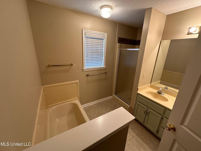 7807 S Chesterfield Dr, Southaven, MS 38671 - bathroom featuring a textured ceiling, tile patterned flooring, vanity, a shower stall, and a garden tub