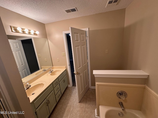 7807 S Chesterfield Dr, Southaven, MS 38671 - full bathroom featuring double vanity, a garden tub, a textured ceiling, and tile patterned flooring