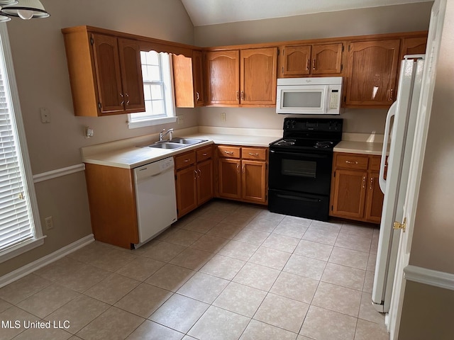 7807 S Chesterfield Dr, Southaven, MS 38671 - kitchen featuring white appliances, a sink, brown cabinetry, vaulted ceiling, and light tile patterned flooring