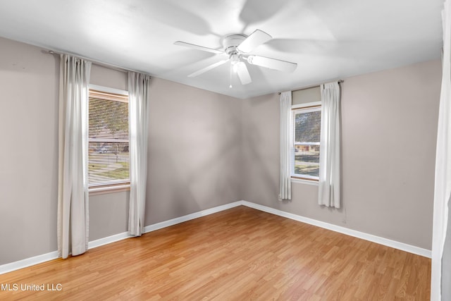 empty room featuring baseboards, ceiling fan, and a healthy amount of sunlight