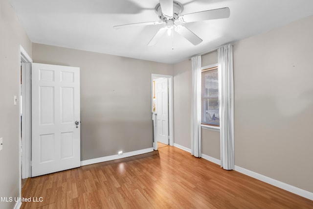 unfurnished bedroom featuring wood finished floors, a ceiling fan, and baseboards