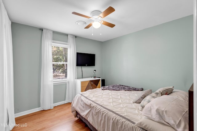 bedroom with baseboards, ceiling fan, and light wood finished floors