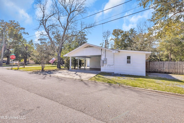 view of front of house featuring a carport, a front yard, fence, and driveway