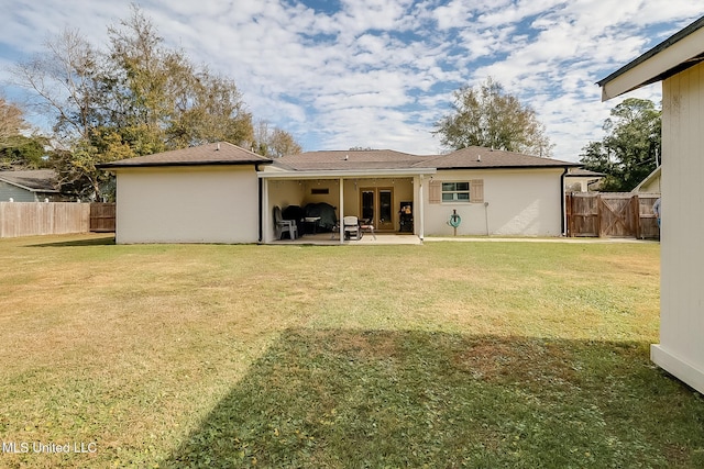 back of house with a patio and a yard