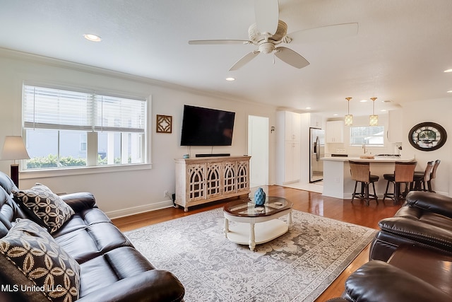 living room featuring ceiling fan, crown molding, hardwood / wood-style flooring, and sink