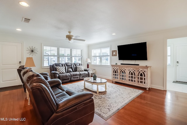 living room with ceiling fan, crown molding, and hardwood / wood-style flooring