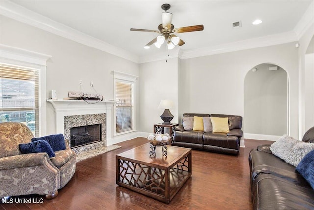 living room with a fireplace, ceiling fan, dark wood-type flooring, and ornamental molding