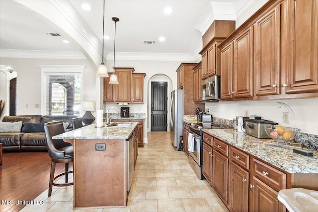 kitchen featuring stainless steel appliances, sink, crown molding, a breakfast bar, and pendant lighting