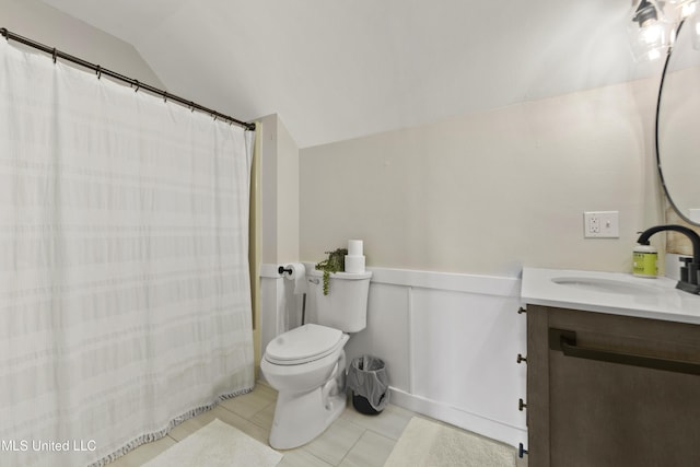 bathroom featuring toilet, tile patterned flooring, vaulted ceiling, and vanity