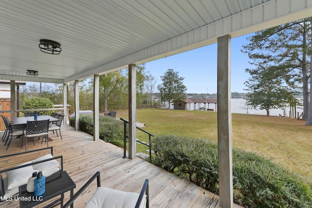 wooden terrace with a yard and a water view