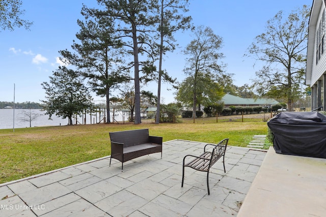 view of patio with grilling area and a water view