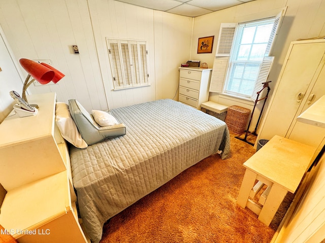 bedroom with carpet and wood walls