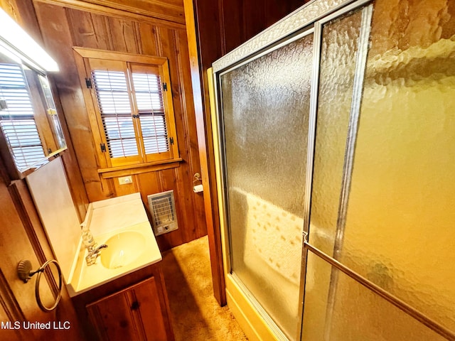 bathroom featuring heating unit, wood walls, a stall shower, and vanity