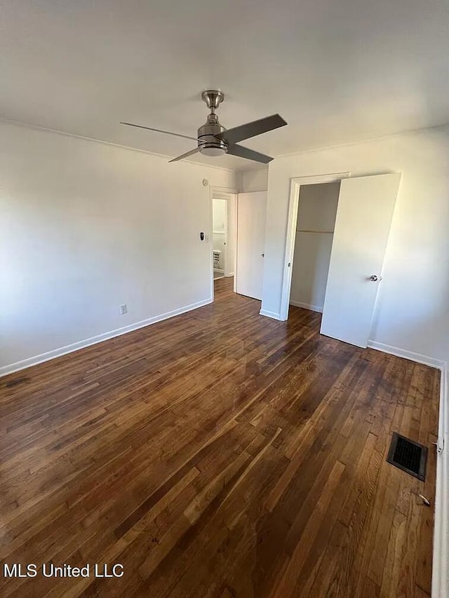 unfurnished bedroom featuring ceiling fan, dark wood-type flooring, and a closet