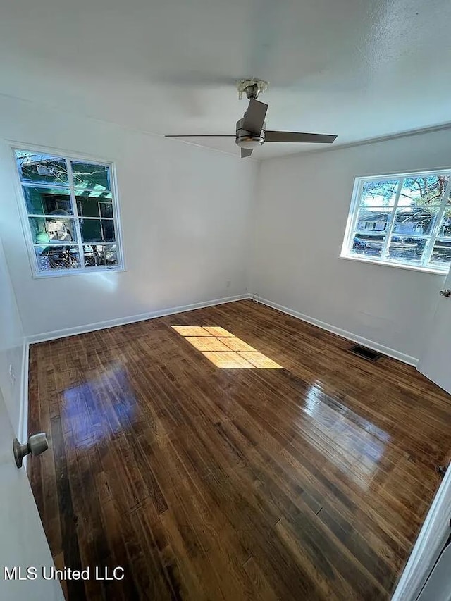 spare room featuring ceiling fan and dark wood-type flooring