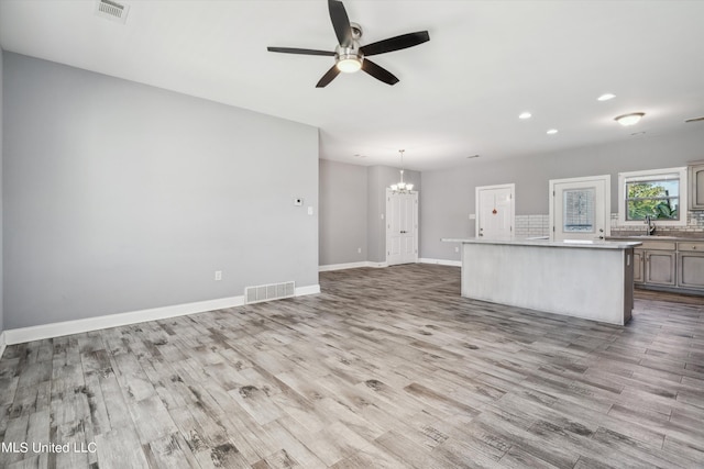 46 Tyro Rd, Holly Springs, MS 38635 - unfurnished living room featuring visible vents, wood finished floors, ceiling fan with notable chandelier, and recessed lighting