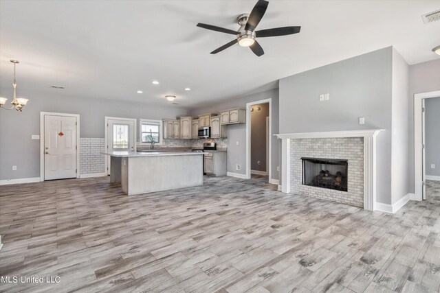 46 Tyro Rd, Holly Springs, MS 38635 - kitchen with a kitchen island, baseboards, open floor plan, light wood-type flooring, and ceiling fan with notable chandelier