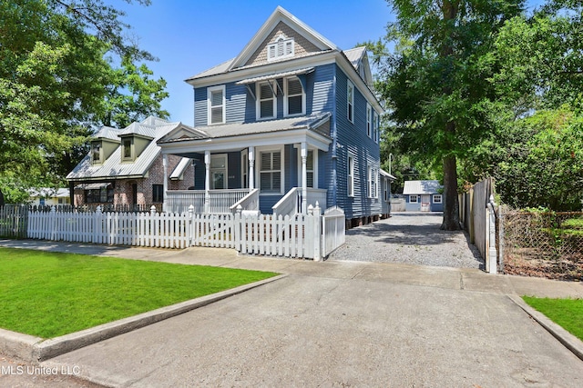 view of front facade featuring covered porch and a front yard