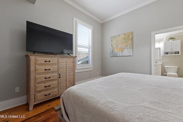 bedroom with dark wood-type flooring, connected bathroom, and ornamental molding