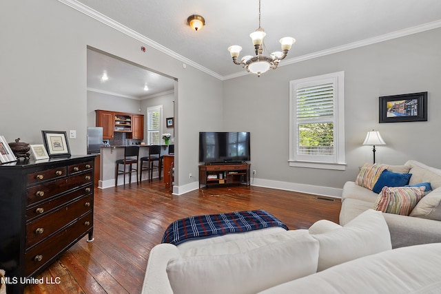 living room featuring dark hardwood / wood-style flooring, an inviting chandelier, and ornamental molding