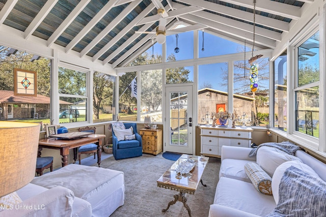 sunroom with lofted ceiling with beams, plenty of natural light, and a ceiling fan