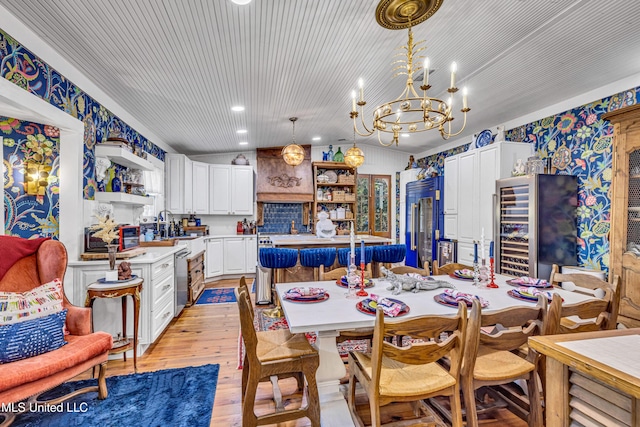 dining area featuring wine cooler, an inviting chandelier, vaulted ceiling, light wood-style floors, and recessed lighting