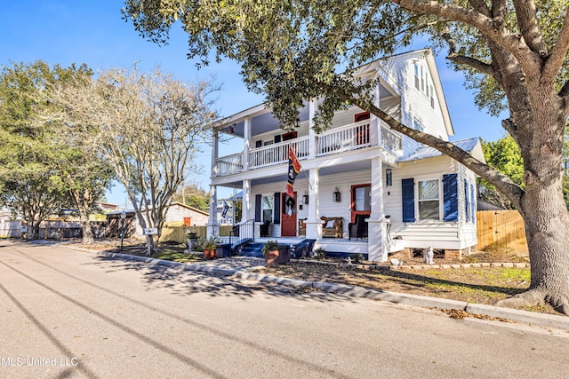 view of front of property with a porch, fence, and a balcony