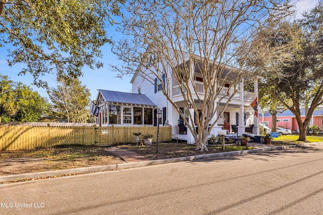 view of front of property featuring a balcony and fence