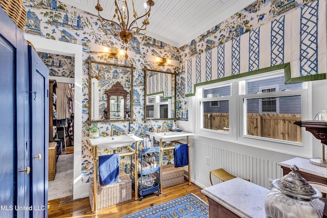 bathroom with a sink, wood finished floors, and a chandelier