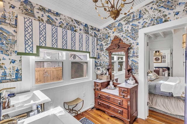 interior space featuring light wood-type flooring, wallpapered walls, and a chandelier