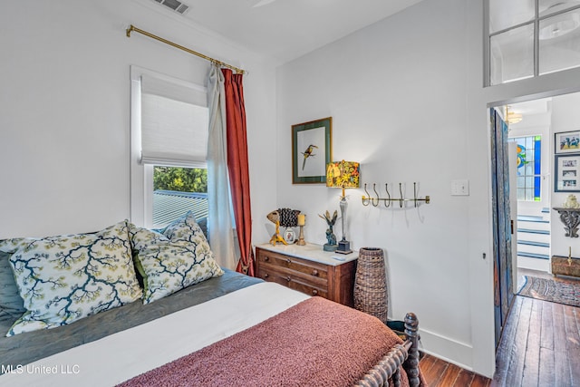 bedroom with baseboards and wood finished floors