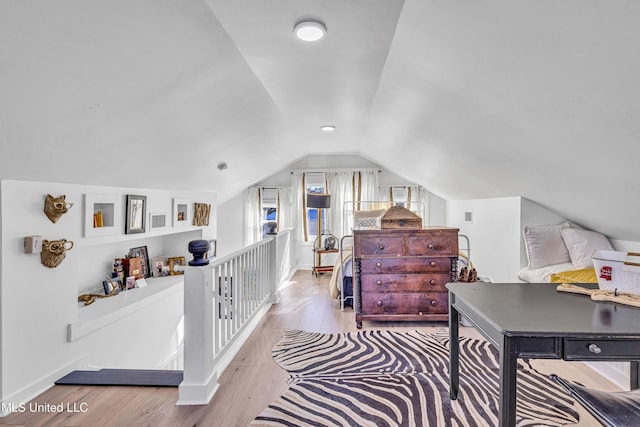 office area featuring light wood-style flooring, baseboards, and vaulted ceiling