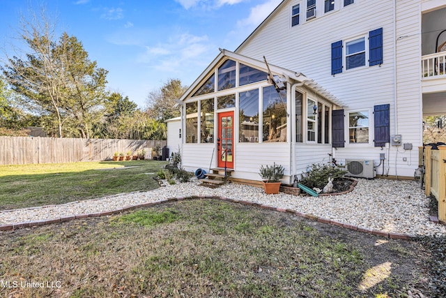 exterior space featuring entry steps, ac unit, a fenced backyard, and a lawn