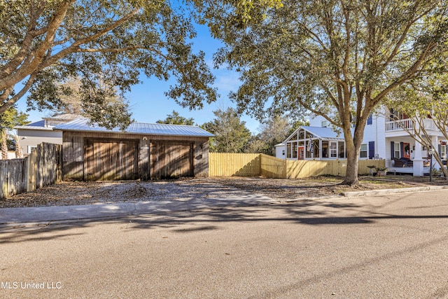 garage featuring gravel driveway and fence