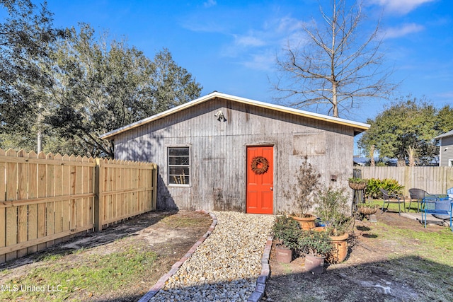 view of outbuilding with a fenced backyard and an outbuilding