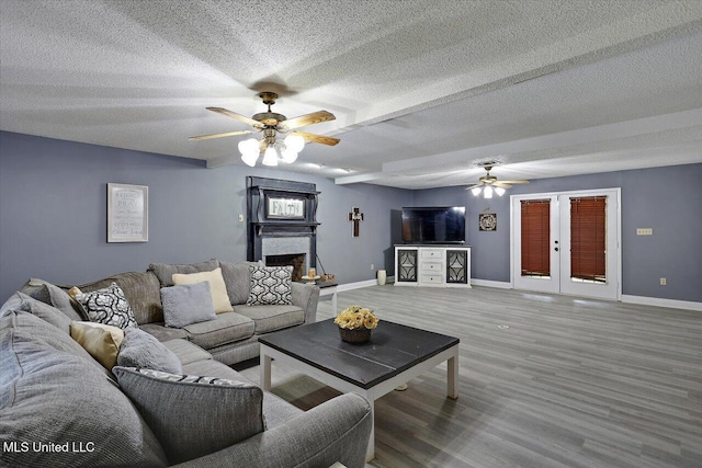 315 Wilson Welch Rd, Mendenhall, MS 39114 - living room featuring a ceiling fan, baseboards, a textured ceiling, wood finished floors, and a fireplace with raised hearth