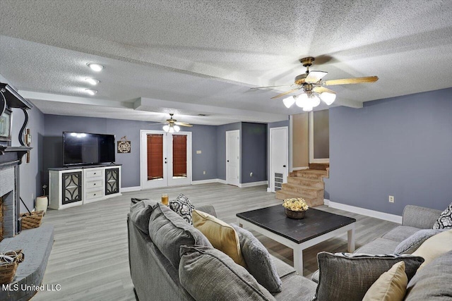 315 Wilson Welch Rd, Mendenhall, MS 39114 - living room featuring a ceiling fan, a brick fireplace, a textured ceiling, baseboards, and light wood-type flooring