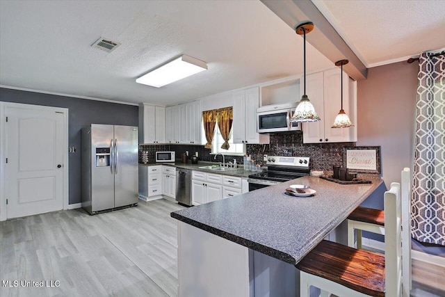 315 Wilson Welch Rd, Mendenhall, MS 39114 - kitchen featuring appliances with stainless steel finishes, a sink, backsplash, a peninsula, and light wood finished floors