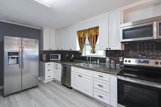 315 Wilson Welch Rd, Mendenhall, MS 39114 - kitchen featuring appliances with stainless steel finishes, a sink, light wood-style floors, white cabinets, and ornamental molding