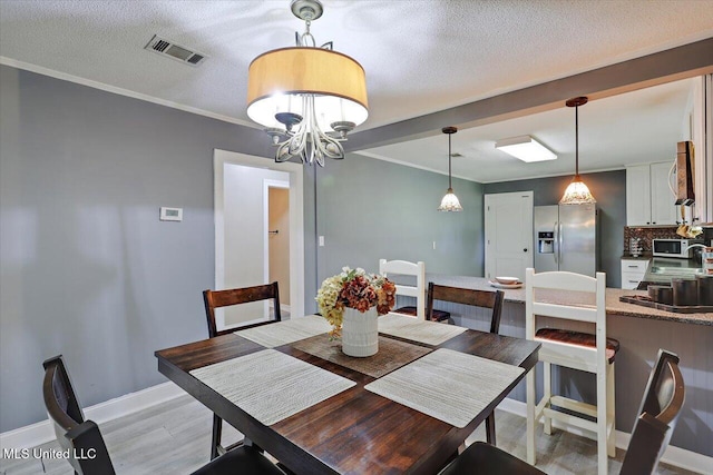 315 Wilson Welch Rd, Mendenhall, MS 39114 - dining room with light wood-style flooring, crown molding, baseboards, a chandelier, and a textured ceiling