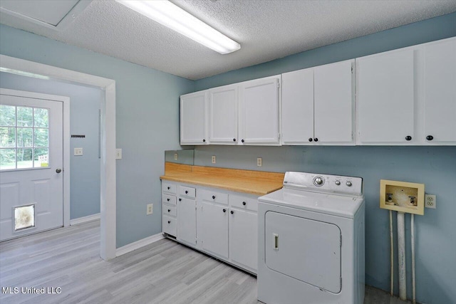 315 Wilson Welch Rd, Mendenhall, MS 39114 - washroom with washer / clothes dryer, cabinet space, light wood-type flooring, a textured ceiling, and baseboards