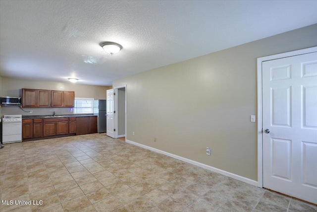 315 Wilson Welch Rd, Mendenhall, MS 39114 - kitchen featuring a sink, range, baseboards, stainless steel microwave, and a textured ceiling