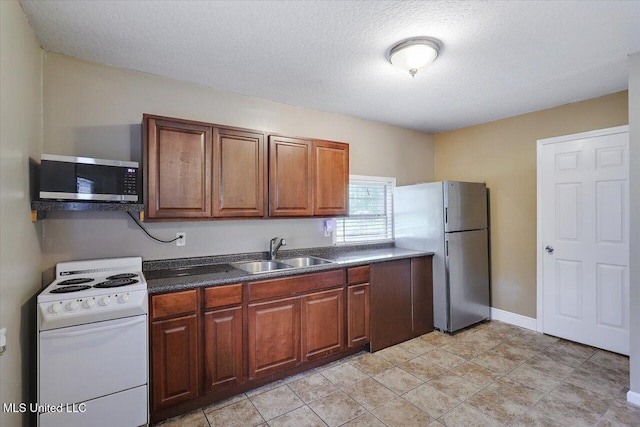 315 Wilson Welch Rd, Mendenhall, MS 39114 - kitchen featuring white electric stove, stainless steel microwave, a sink, freestanding refrigerator, and dark countertops
