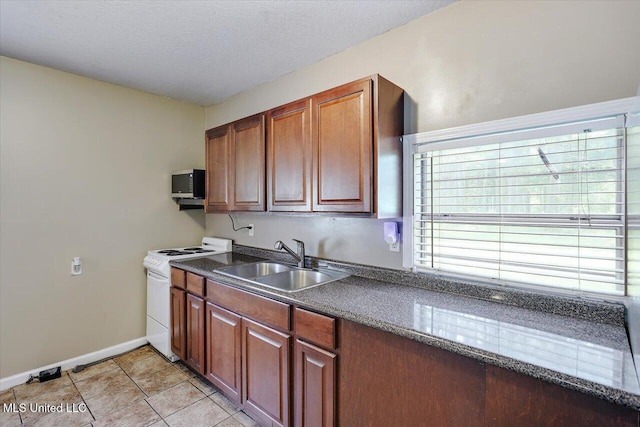 315 Wilson Welch Rd, Mendenhall, MS 39114 - kitchen with white electric range, a sink, stainless steel microwave, baseboards, and brown cabinetry